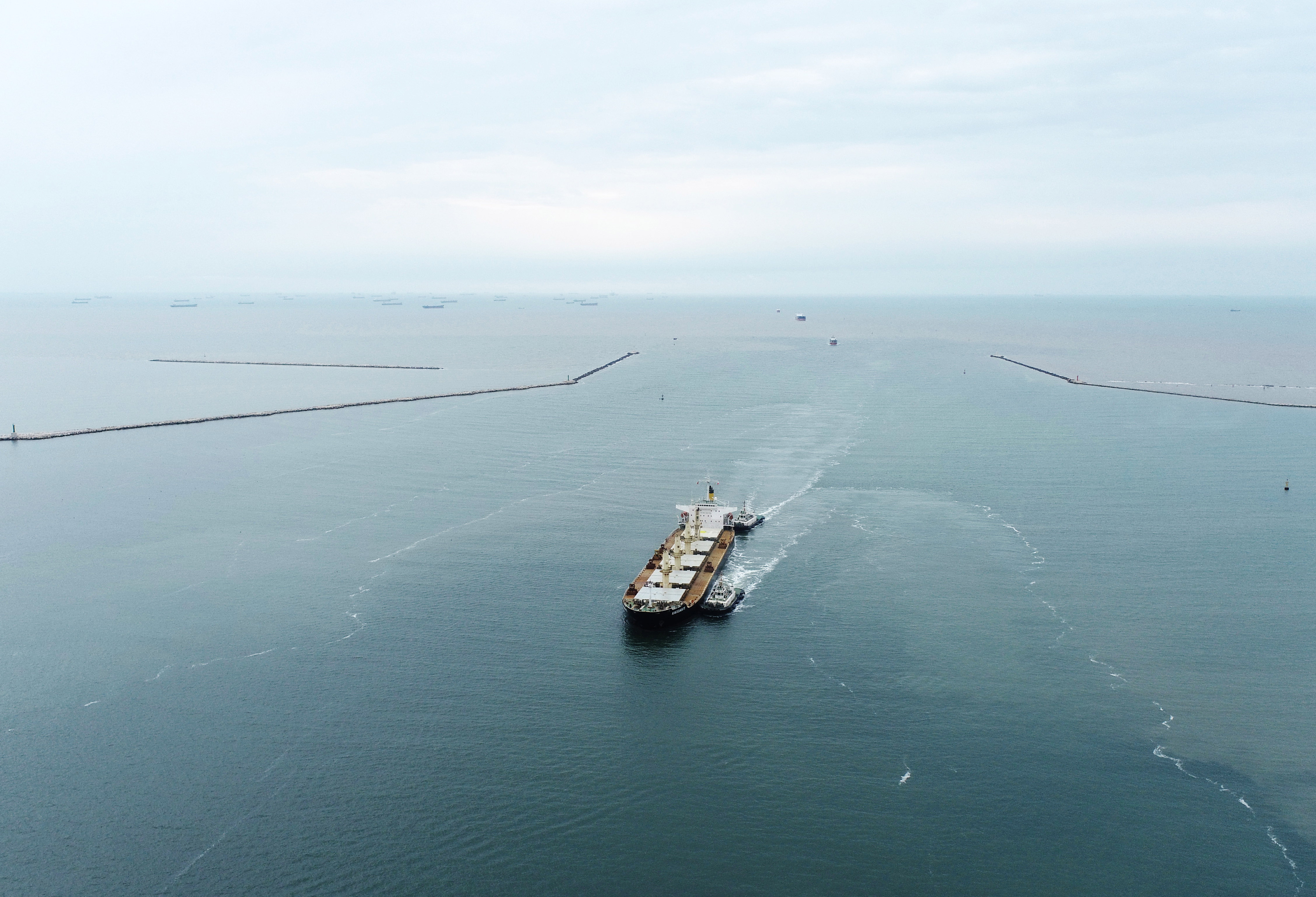 9月25日,一艘轮船在拖轮的引导下通过唐山港京唐港区25万吨级航道向